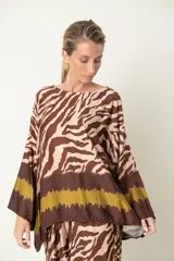 Blusa italiana con estampado de cebra en tonos beige y azul marino, con guarda marrón en el bajo. De calce holgado y mangas tres cuartos.
