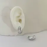 Par de caravanas plateadas con forma de media luna, de acero quirúrgico hipoalergénico con baño en oro 18K.