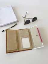 Billetera de cuero con estampado reptil en color marrón y fucsia con detalles en blanco. Tiene un sistema de cierre con broche y monedero externo.