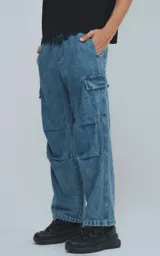 Pantalón de jean celeste con corte holgado, bolsillos laterales tipo cargo y cintura elástica.