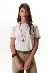 Remera blanca de manga corta con cuello redondo y detalle de costuras en contraste en cuello y mangas.