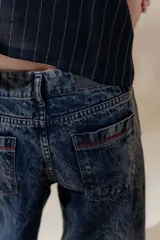 Pantalón de jean denim 100% algodón con tiro medio y piernas anchas, con 5 bolsillos y detalle de pespuntes a contra tono.