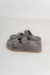 Sandalias color rosa con doble hebilla ajustable y suela marrón.