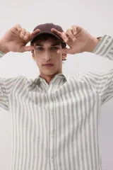 Camisa de manga larga con cuello inglés, a rayas verticales grises y blancas, con bolsillo en el pecho.
