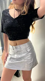 Top corto negro con escote en V, mangas cortas de tul y lentejuelas.