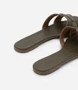 Sandalia plana de cuero sintético color negro, con puntera cuadrada y tiras anchas en forma de H.