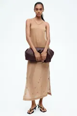 Musculosa larga color beige en tejido de punto transparente con lino en la trama. Modelo ajustado con escote en U y costura decorativa adelante y atrás.