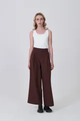 Pantalón de poliéster color marrón oscuro, de tiro alto, corte ancho y pinzas frontales.