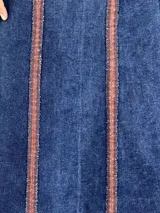 Pollera larga de jean azul con corte acampanado y costuras verticales en color ladrillo.