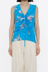 Top sin mangas con estampado de olas en tonos azules, corte recto, escote en V pronunciado y cordones ajustables.