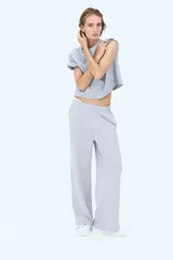 Pantalón de felpa celeste, de corte relajado con cintura elástica fruncida, bolsillos laterales discretos y piernas rectas.