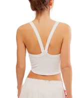 Top deportivo blanco, ajustado al cuerpo, con escote redondo en el frente y espalda cruzada. Presenta un dobladillo recortado que deja ver el abdomen.