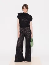 Pantalón calado negro de corte palazzo con cintura de lycra y cierre lateral.