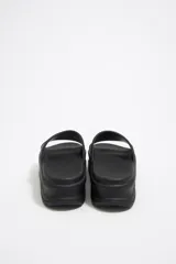 Sandalias tipo ojotas color negro con plataforma y logo de la marca en la tira superior y en la plantilla.