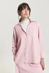 Camisa de viscosa color rosa, de corte recto y amplio, con cuello camisero y escote en V.