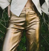 Pantalón de cuero dorado, de corte recto y tiro medio.