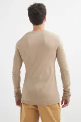 Sweater de acrílico color beige, de manga larga y cuello redondo con botones.