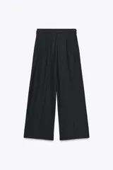 Pantalón negro de tiro alto, corte ancho y largo midi. Incluye bolsillos delanteros, pinzas y cinturón de la misma tela.