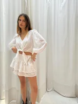 Pollera corta blanca de broderie, con volantes y diseño ligero.
