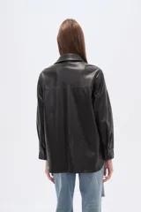 Sobrecamisa negra de efecto cuero, con cuello camisero, botones frontales y dos bolsillos de parche con solapa en el pecho. Presenta un calce holgado.