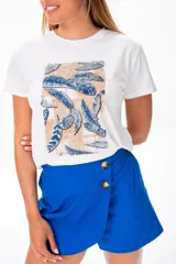 Remera blanca de algodón con estampado de plumas en tonos azules y beige.