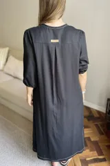 Vestido azul de lino, corte recto, largo midi, escote en V, manga corta, bolsillos laterales y tajos en los laterales.