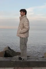 Campera puffer de corderoy con estampado paisley en tonos beige y cuello alto.