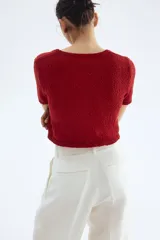 Cárdigan rojo de tejido slub con cuello en V, manga corta y cierre frontal con botones.