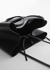 Bolso shopper grande, sin forro interior, con asas decoradas con nudos y cierre de botones magnéticos.