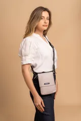 Bandolera tipo phone bag pequeña, color marrón claro, con correa de galón regulable. Tiene un compartimento principal y un bolsillo adicional con tapa.