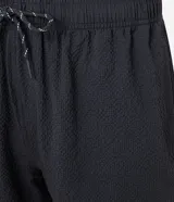 Bermuda de microfibra color beige, con cintura elástica y cordón ajustable. Presenta textura en el tejido y un bolsillo lateral.