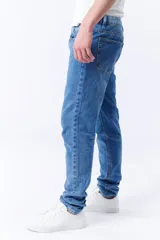 Pantalón jean de corte slim color azul medio, con bolsillos delanteros y traseros.