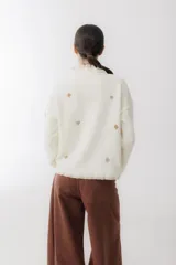 Sweater crudo de tejido de punto con cuello alto con volados y bordados de símbolos de naipes.