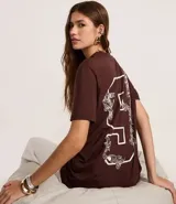 Remera marrón de algodón con estampa frontal con la palabra 'Culture' en tipografía gótica y otros textos en blanco. Corte recto y mangas cortas.