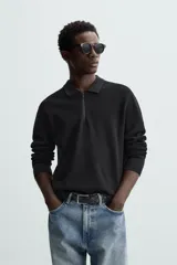 Polo de hombre regular fit, tejido de punto con mezcla de viscosa, color negro. Tiene cuello solapa con cierre frontal de cremallera, manga larga y acabados en rib.