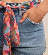 Short de jean de cintura alta con trabillas, cierre por botón y cremallera, bolsillos delanteros y traseros. Incluye cinturón pañuelo con estampa tropical de cocoteros.