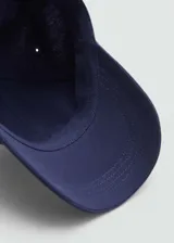 Gorra de béisbol blanca de algodón con mensaje bordado en el frente y correa ajustable en la parte posterior.