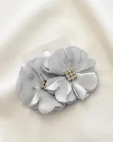 Par de caravanas plateadas con forma de flor de tela y centro de strass.