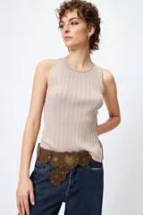 Musculosa de punto color beige, con textura acanalada y detalle de trenzado lateral ajustable.
