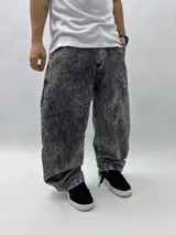 Pantalón de jean gris con efecto lavado, corte holgado y tiro alto. Presenta bolsillos delanteros y traseros, y estampados con letras en la parte trasera.