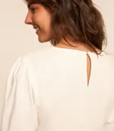 Blusa color amarillo claro, confeccionada en viscolino, con cuello redondo y mangas cortas abullonadas.