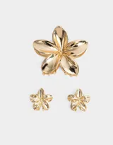 Set de tres broches dorados de metal con forma de flor hawaiana, en dos tamaños: uno de 8 cm y dos de 3 cm.