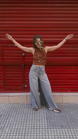 Pantalón de jean celeste de tiro medio con pierna extra ancha y caída fluida, con bolsillos delanteros y traseros, y cierre frontal con cremallera y botón metálico.