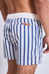 Short de baño azul marino con rayas verticales blancas, corte a la mitad del muslo y pretina elástica.