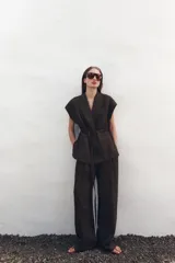 Chaleco color crudo confeccionado en hilatura con lino y viscosa. Tiene cuello solapa de muescas y manga sisa caída. Cierre frontal cruzado con cordones.