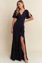 Vestido largo de color azul marino, con escote en V con detalle de encaje, mangas cortas con abertura y falda con tajo lateral y volados.