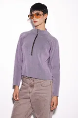 Sweater lila de punto con cuello alto y cierre de cremallera metálica.