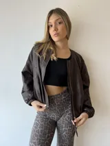 Campera marrón de cuero sintético, corte holgado, con cierre frontal y mangas largas con puños elásticos.