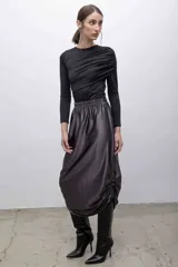 Top negro de mangas largas con frunces en el hombro izquierdo.