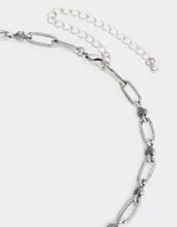 Collar corto plateado con cadena de eslabones ovalados unidos por pequeñas secciones de alambre enrollado.